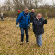 Ihre Stimme für Naturschutz-Engagement von Freiwilligen der Lebenshilfe Ein Mann und eine Frau ziehen einen Baum von einer Wiese